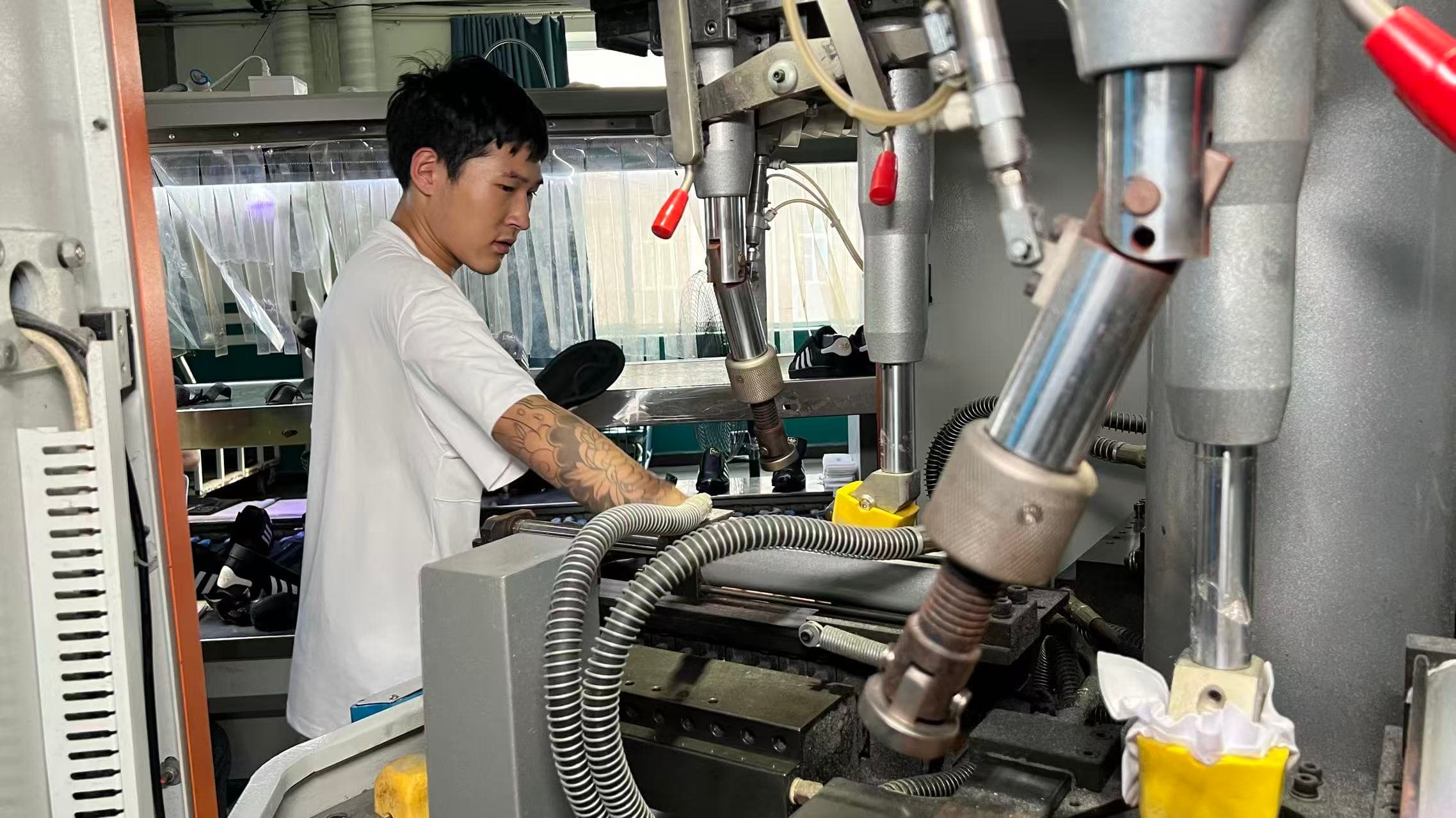 Mingjian Footwear operator running industrial lasting machinery