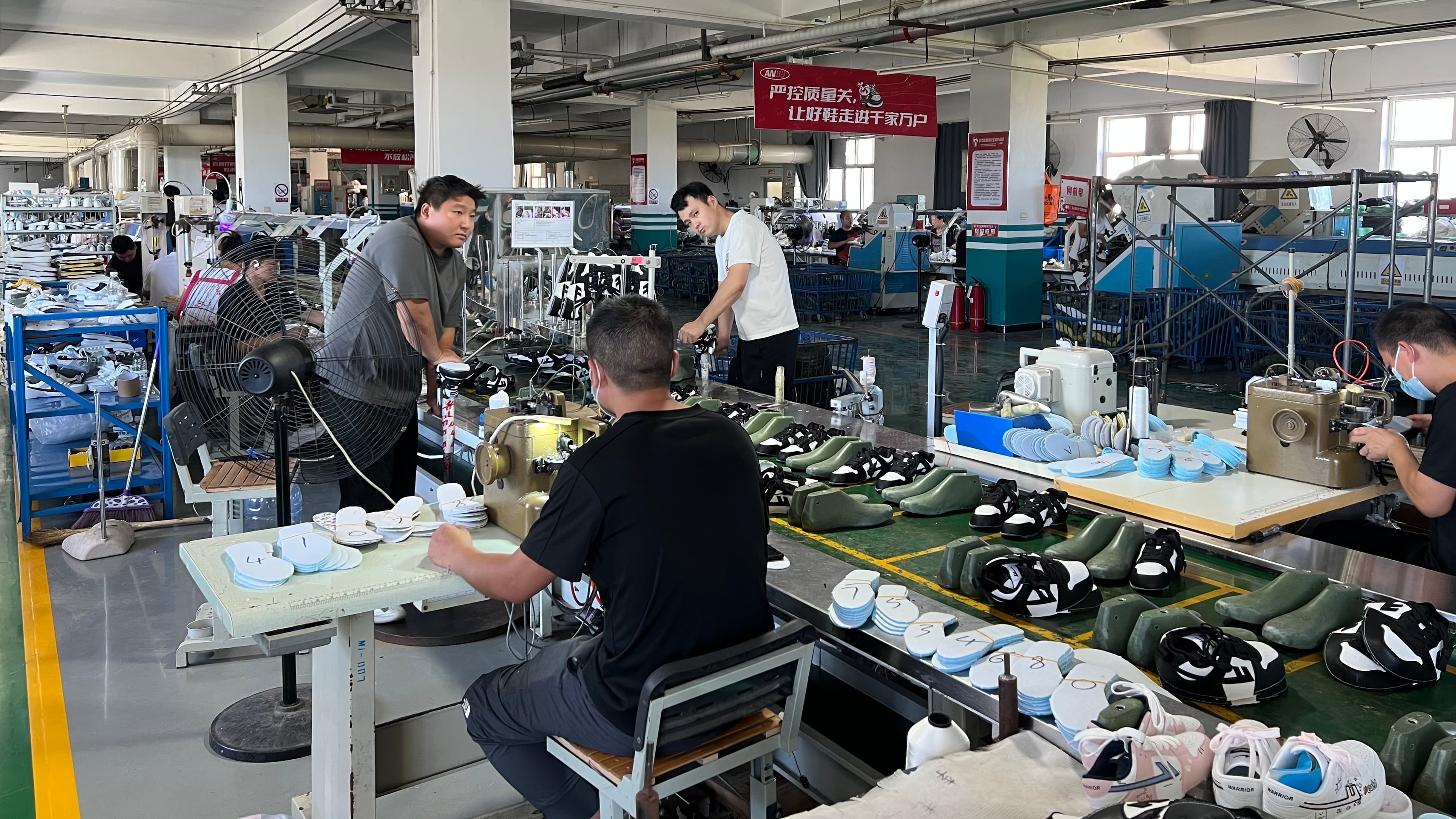 Mingjian Footwear assembly line with lasts, insoles, and technicians at work
