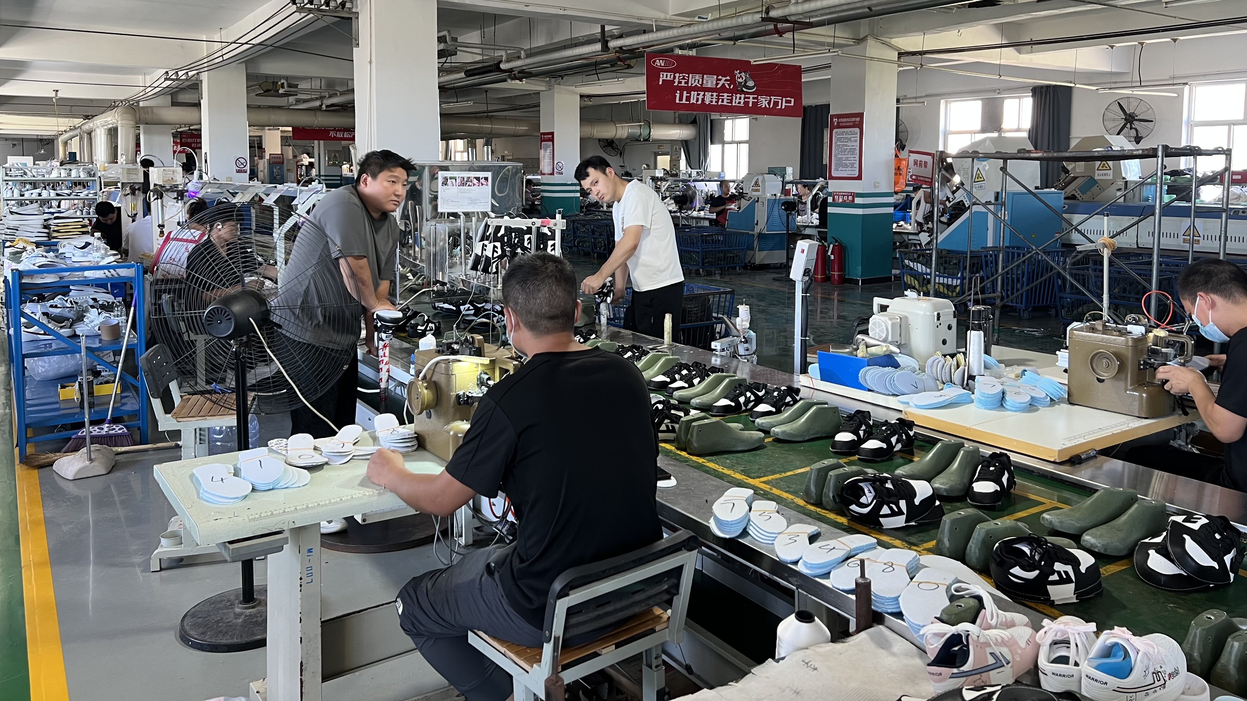 Mingjian assembly line with lasts, insoles, and technicians at workstations