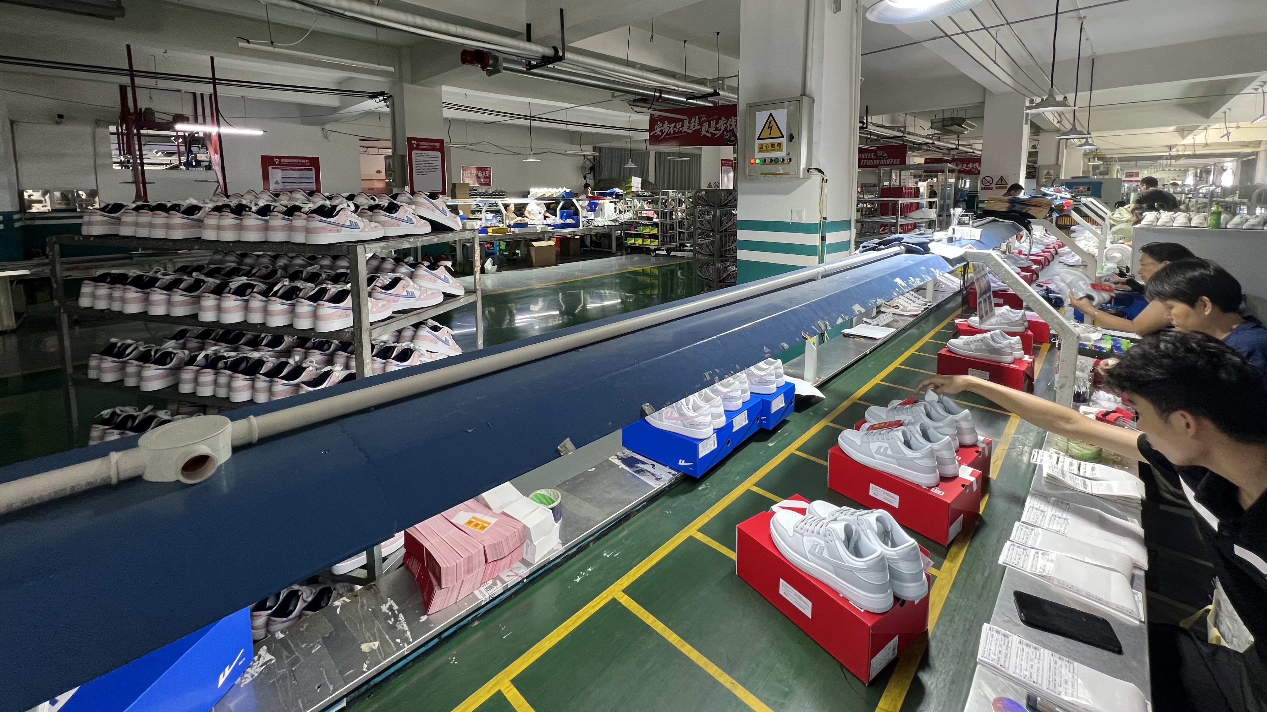 Mingjian packing line with sneakers, boxes, and technicians at work