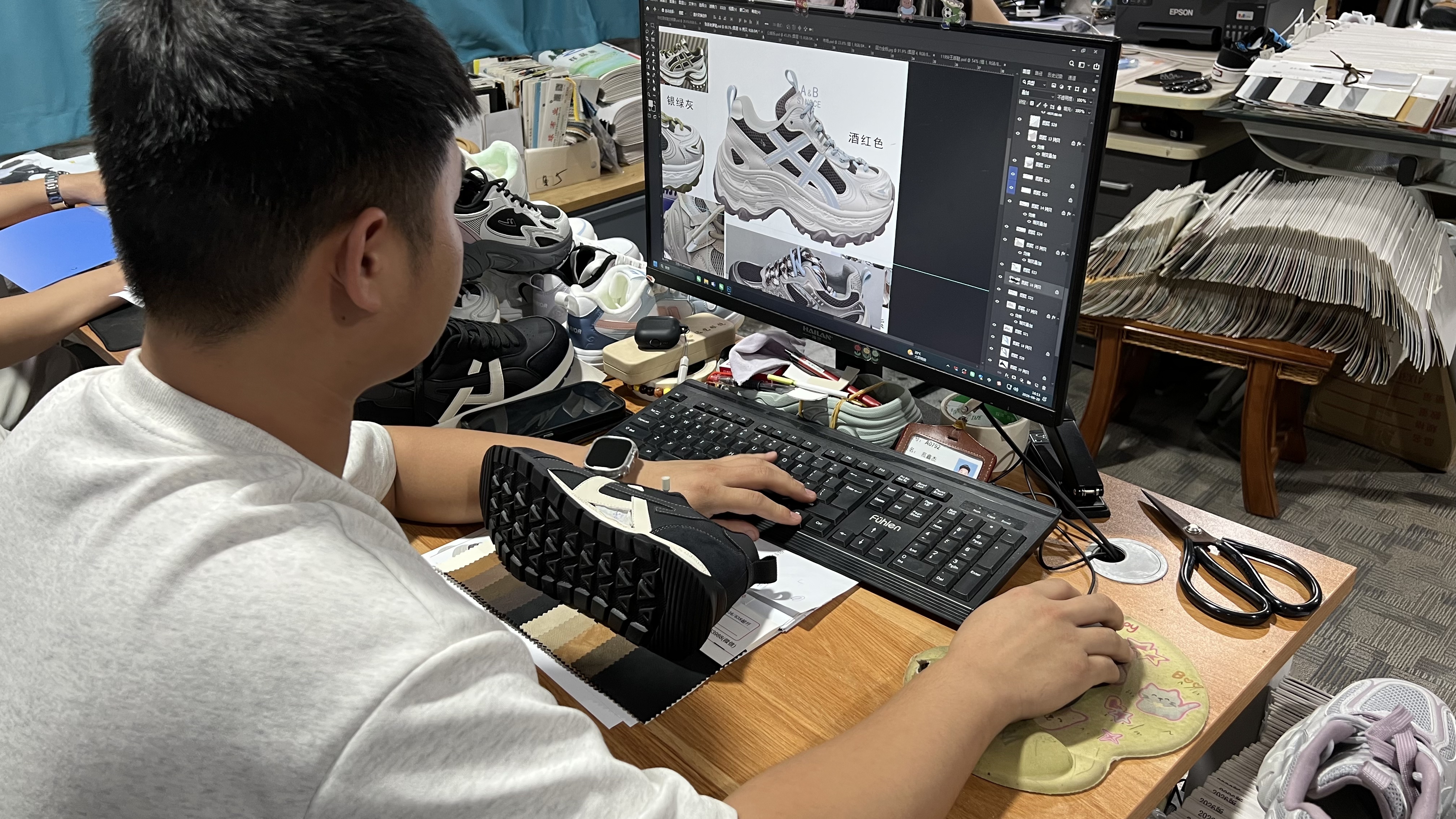 Mingjian designer reviewing sneaker colorways on screen at the sample desk